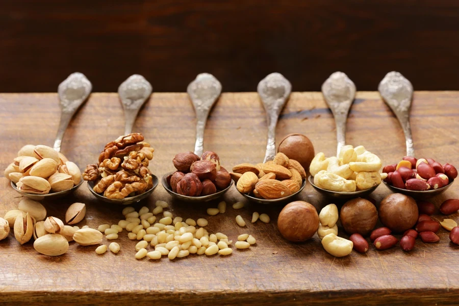 Various kinds of nuts (cedar, cashew, hazelnuts, walnuts) in spoons