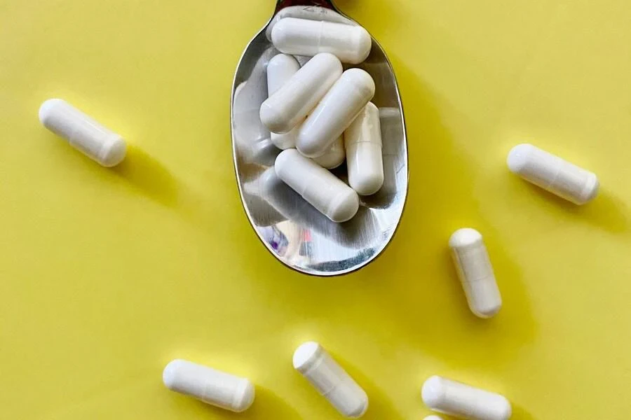 White capsules spilling out of a spoon