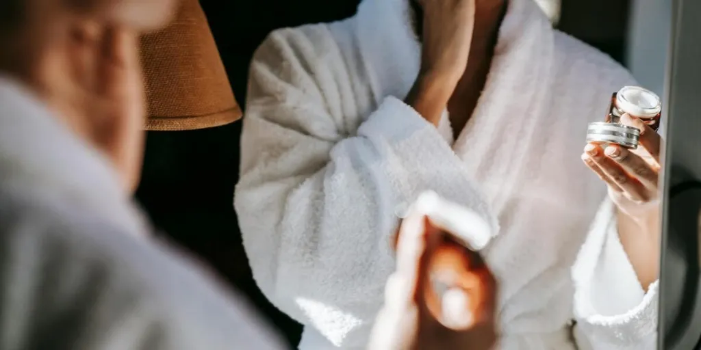 Woman applying cream on her face