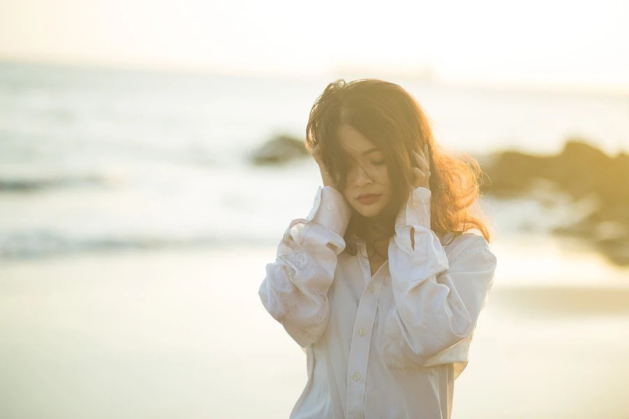 Woman holding her hair, which is flying with the wind