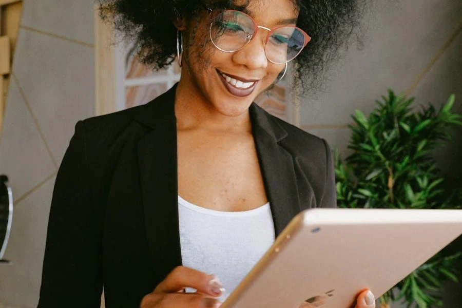 Woman in a black suit smiling at her iPad