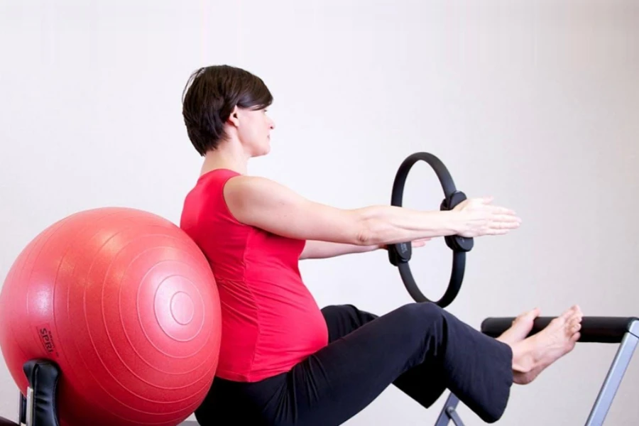 Woman in a red shirt using pilates equipment