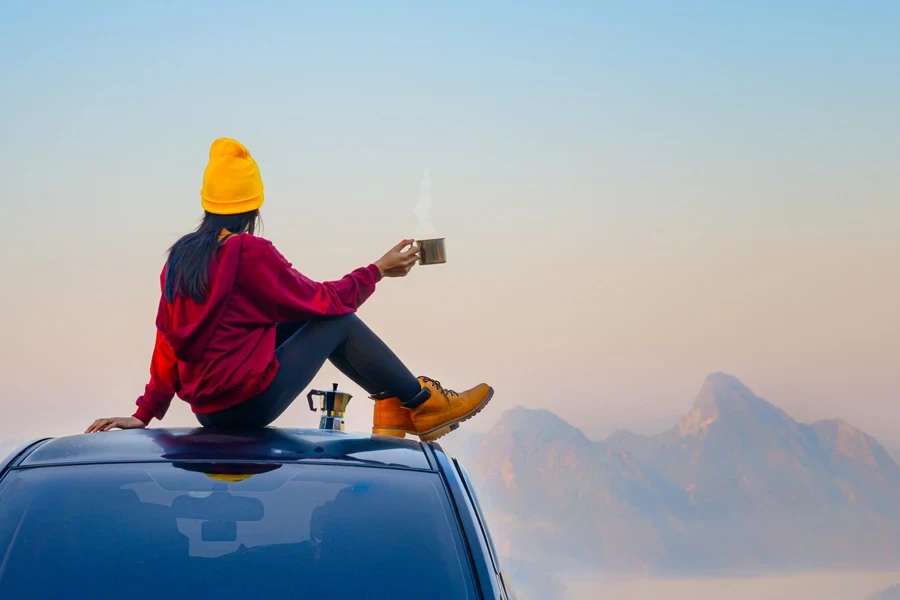 Woman sitting on a car in adventure leggings