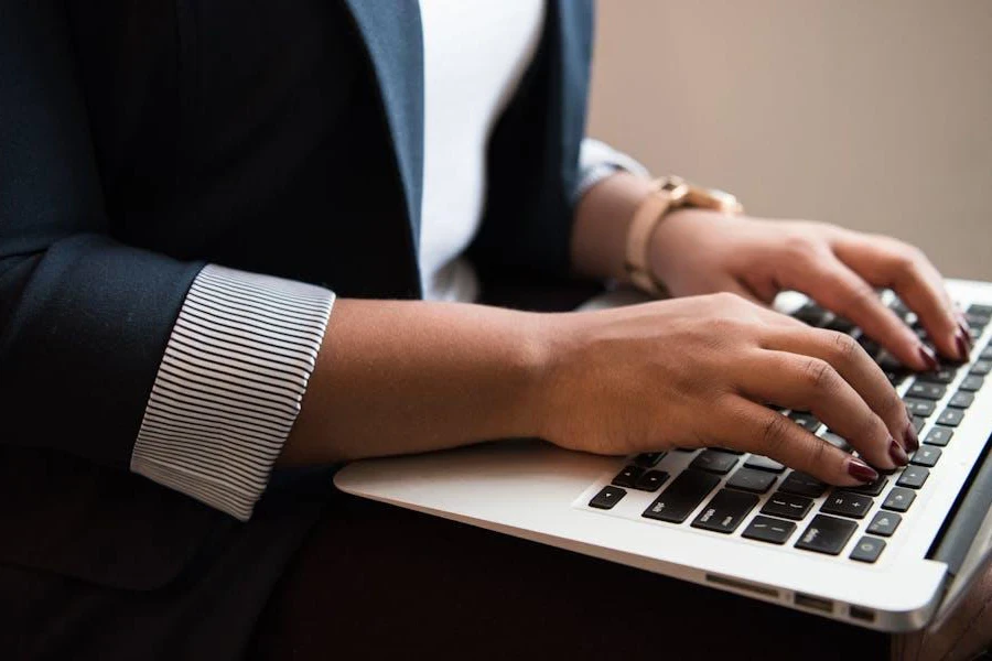 Woman typing on her silver laptop