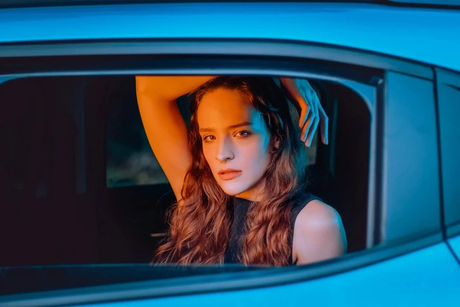 Woman with beautiful hair looking outside from the car window