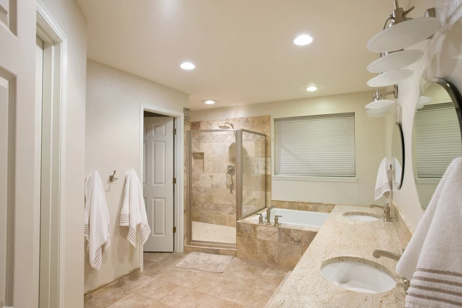 a bathroom with travertine floors and vanities