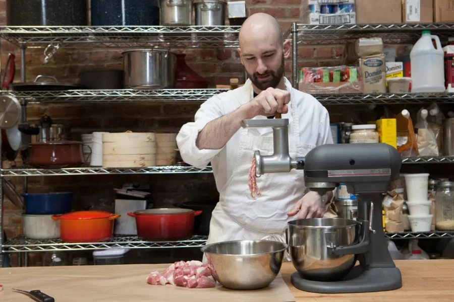 A butcher making ground meat with a grinder