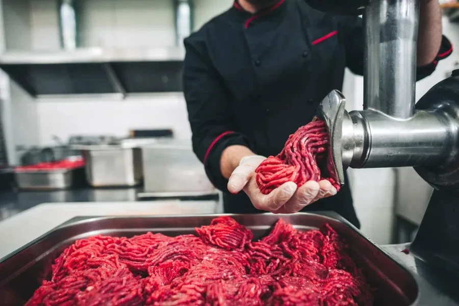 A chef doing a large batch of ground beef bone