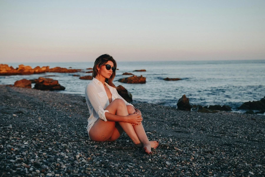 a girl sitting on a beach