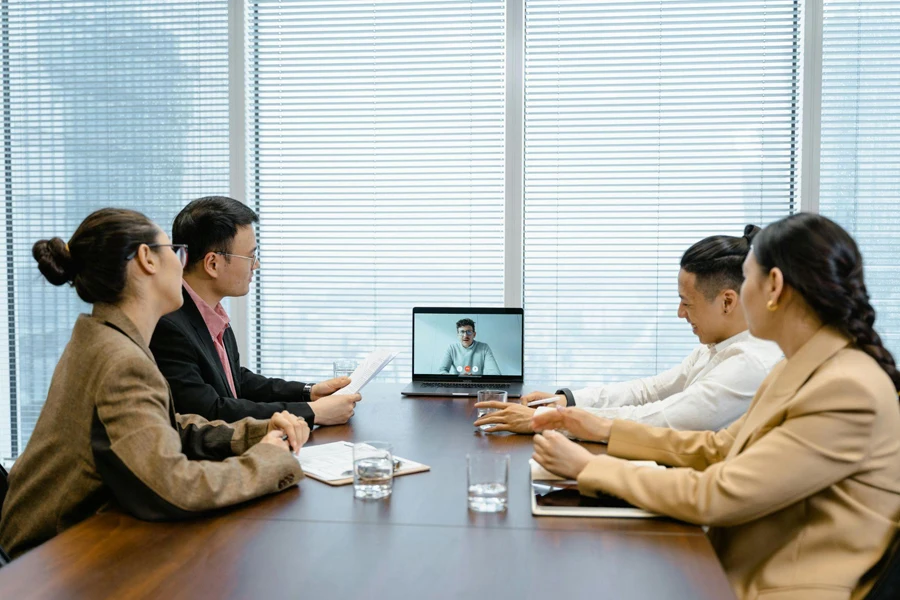 a group of people in a meeting with a man using video call