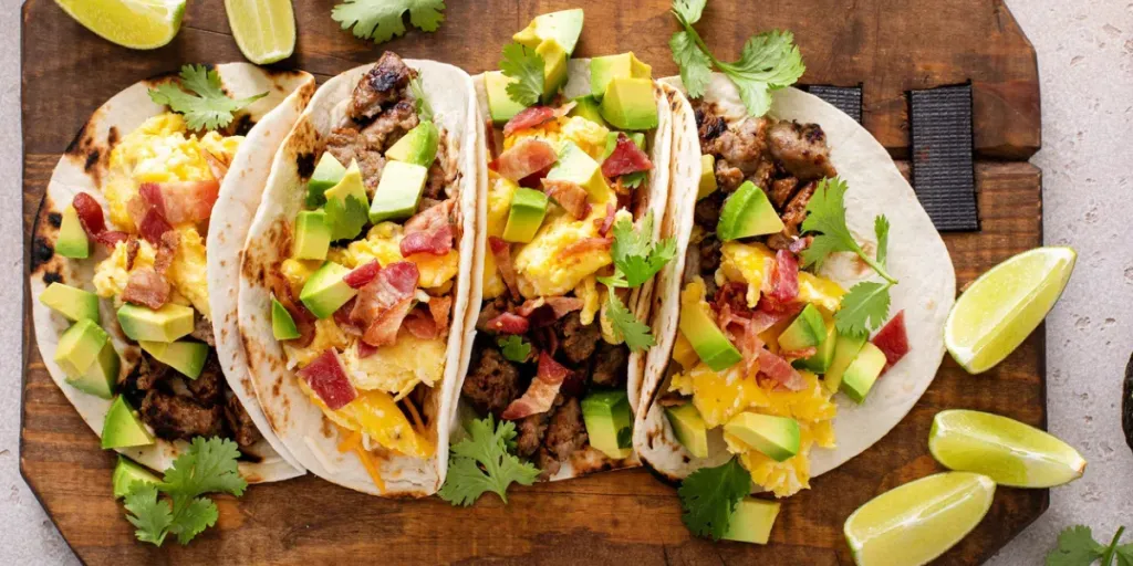 Breakfast tacos with tortilla, sausage, eggs, bacon and avocado