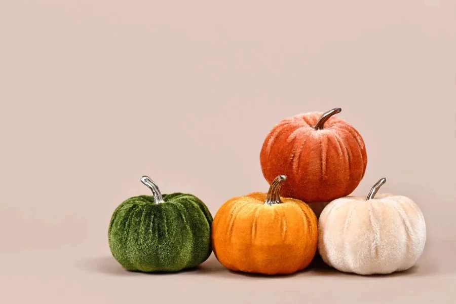 four velvet pumpkins on a plain background