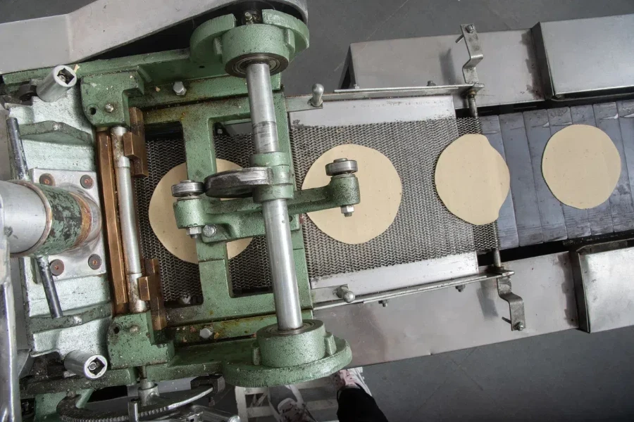 Machine to make tortillas Mexican tortilleria with metal band and a kilo of tortillas wrapped in white paper