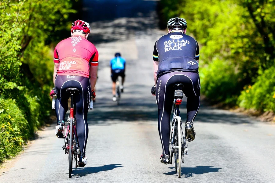 two bicyclists are riding down the road together