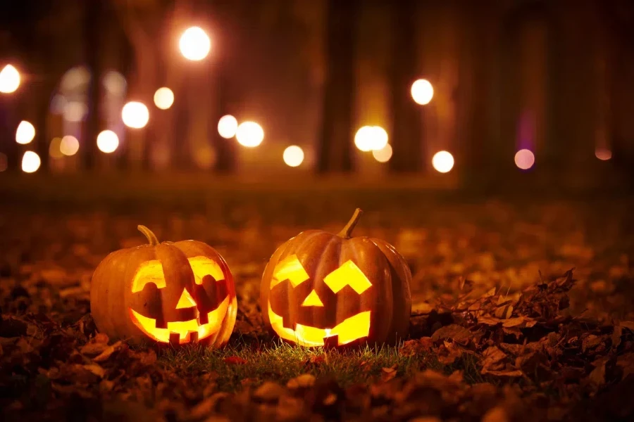 two pumpkin lanterns lit up at night