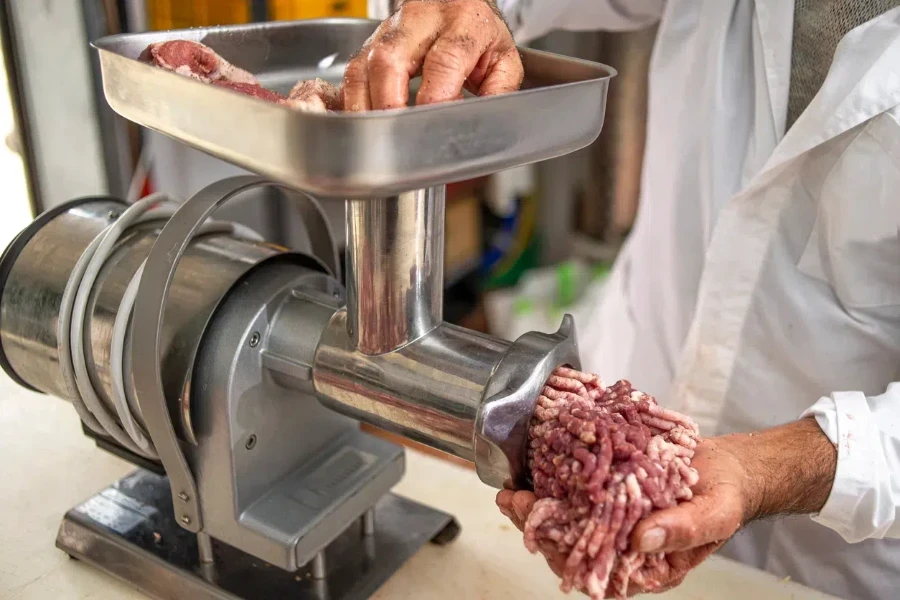 Woman grinding meat and bones on a grinder