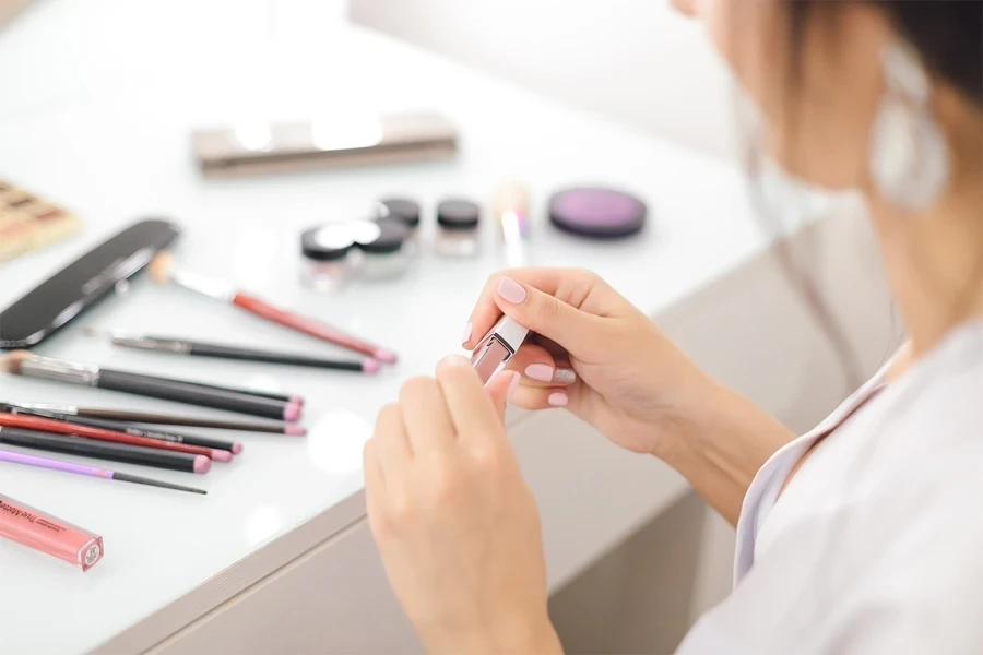 young woman holding a lip balm in her hands