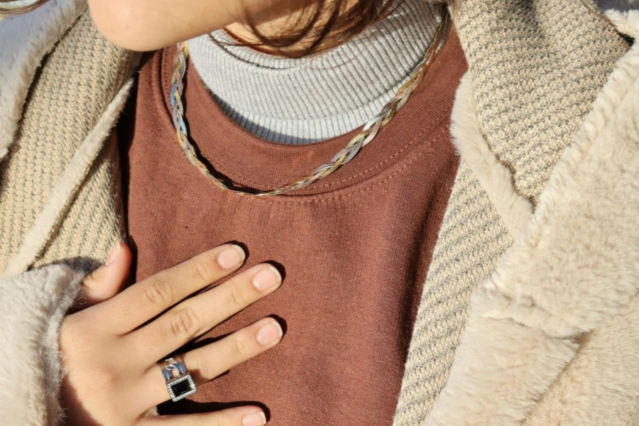 A Close-Up Shot of a Person Wearing a Necklace and a Ring