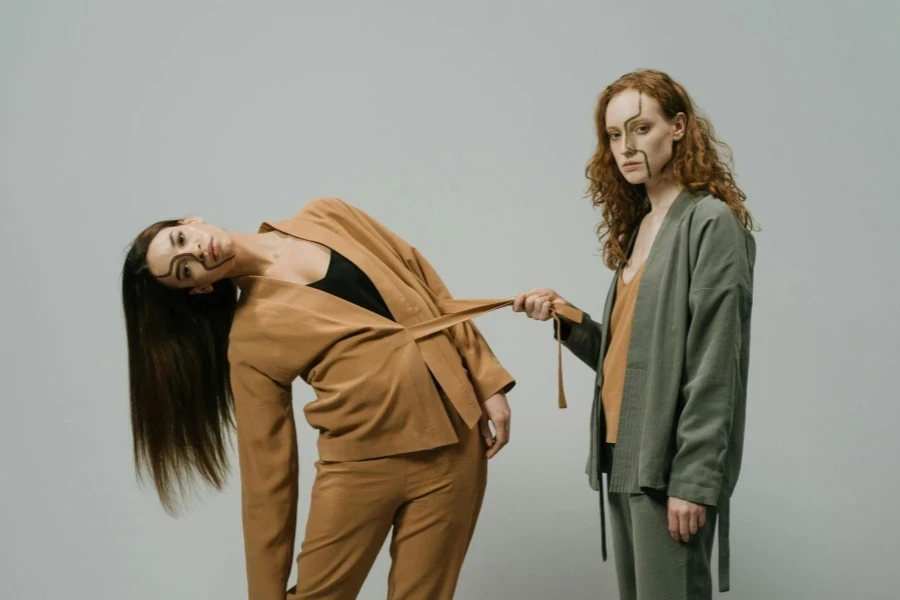 A Woman Holding another Woman's Belt while Posing Together