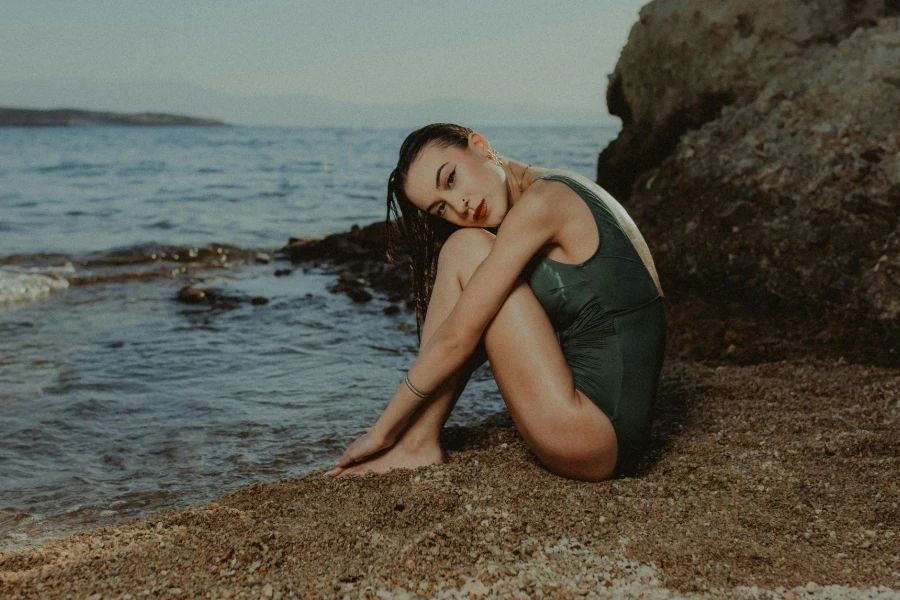 A Woman in a Swimsuit Sitting on the Beach