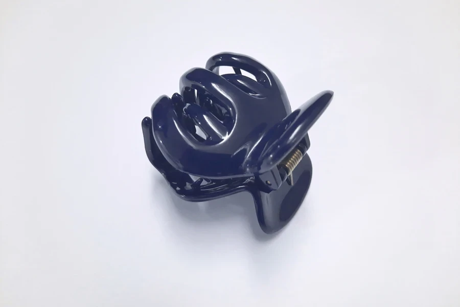 A blue mini claw clip on a grey background