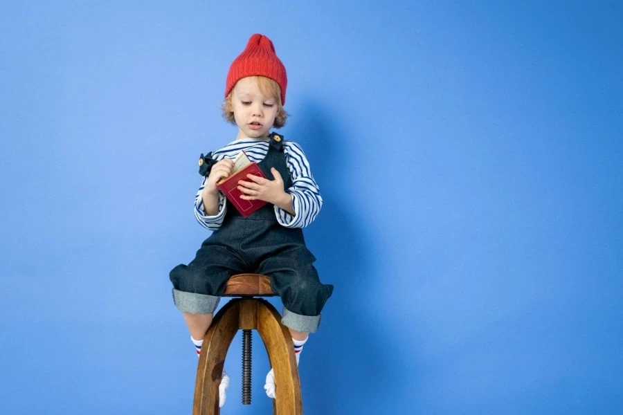 A boy sitting on brown wooden chair