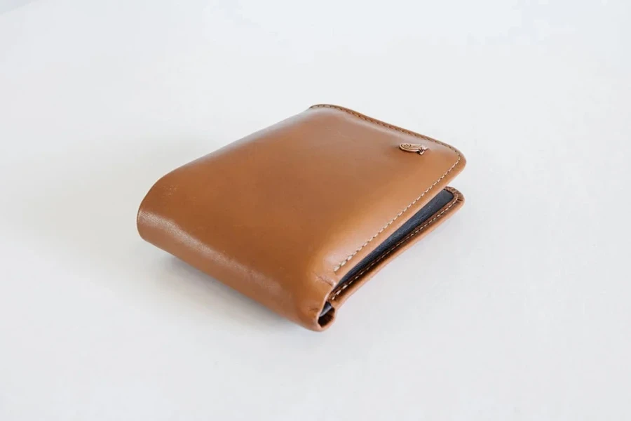 A brown leather bi-fold wallet on a white background