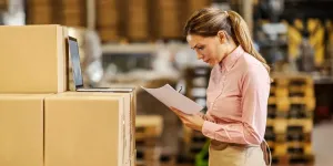 A female food factory worker standing in warehouse and checking on goods