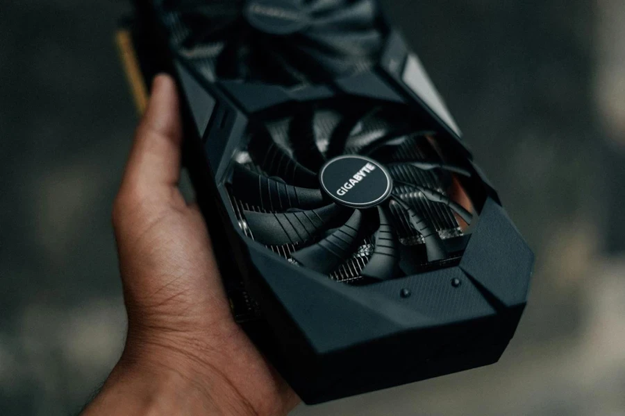 A hand holding a black GPU