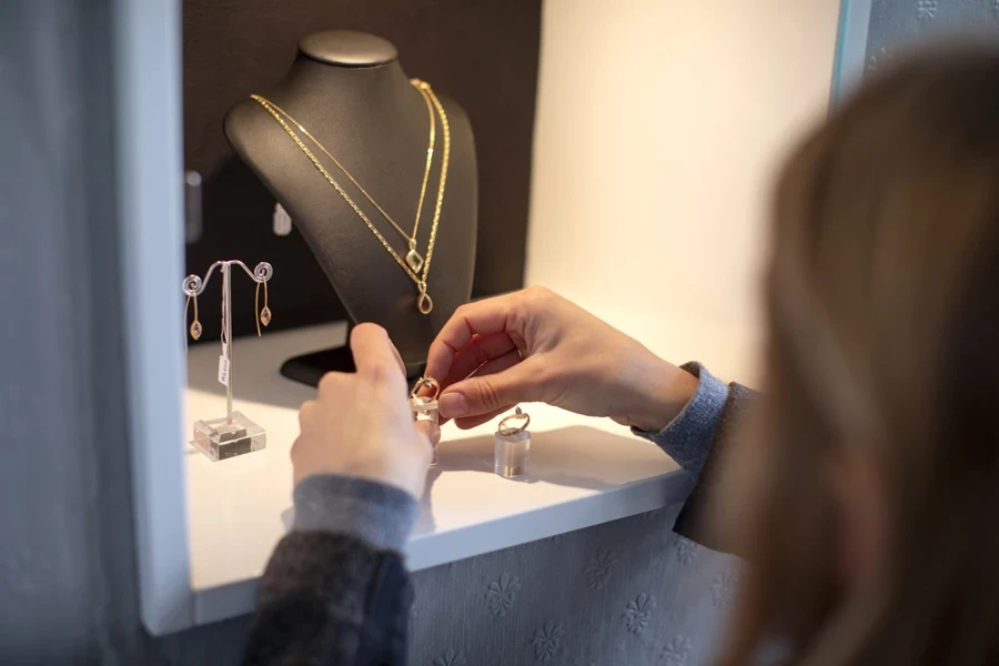 A jewelry store owner arranging her display case