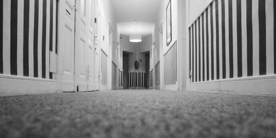 A long hallway with white walls and black and white striped walls