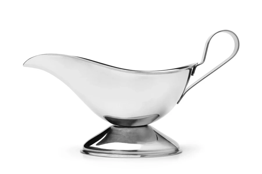 A metal, minimalistic gravy boat on a white background