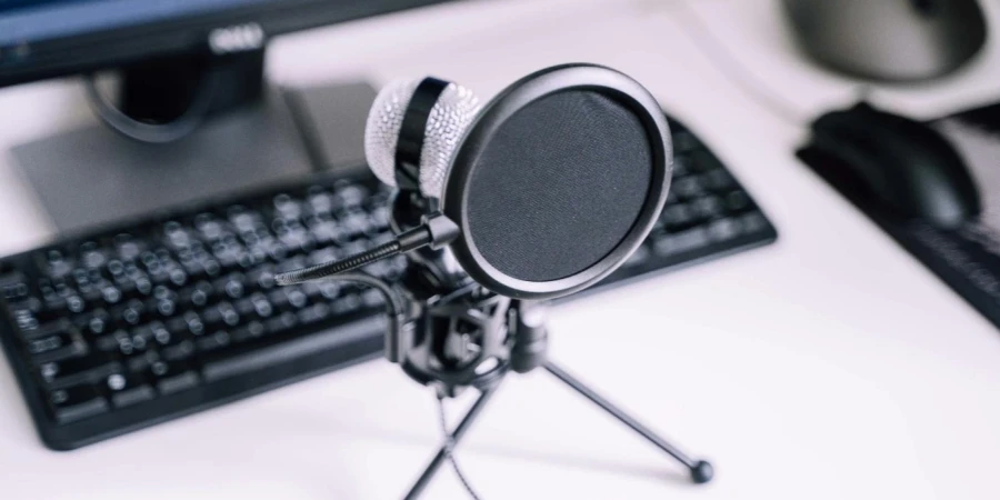 A microphone on a stand in front of a computer