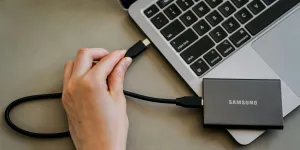 A person is plugging a charger into a laptop