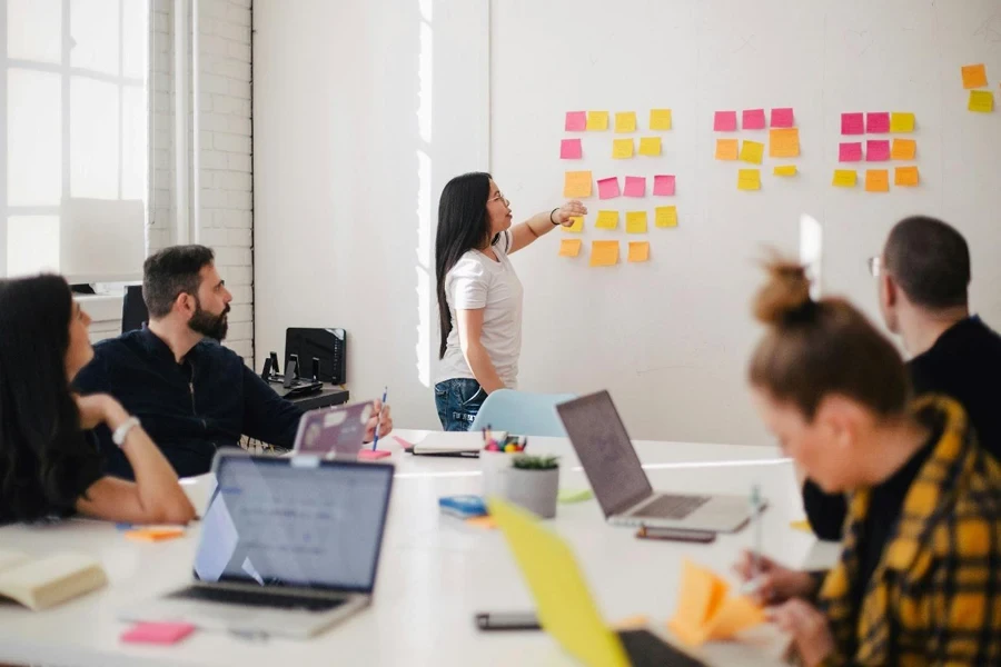 A person pointing at a wall with sticky notes