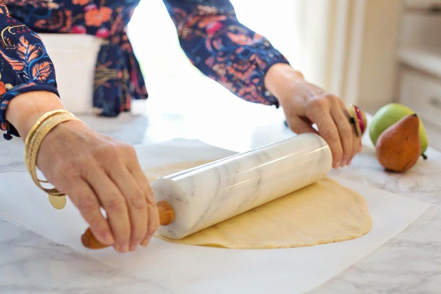 A person rolling out dough with a rolling pin