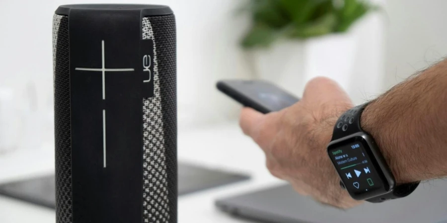 A person using a speaker wearing a smart watch