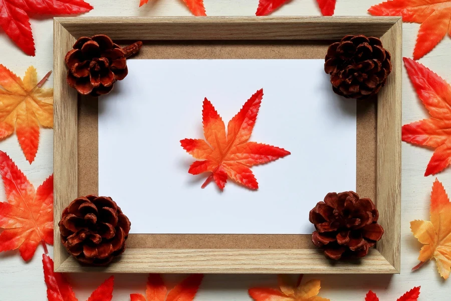 A shallow, open shadow box with leaves and pine cones