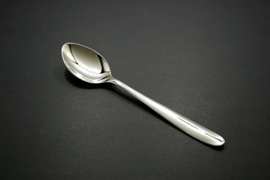 A single tablespoon on a black background