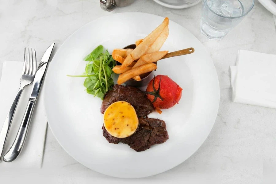 A steak knife and a fork near a dish