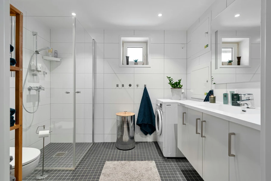 A white bathroom with a black and white floor