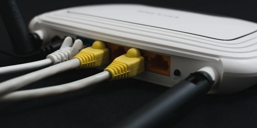 Een witte modem met gele en zwarte kabels