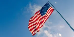 Американский флаг США на флагштоке развевается на ветру