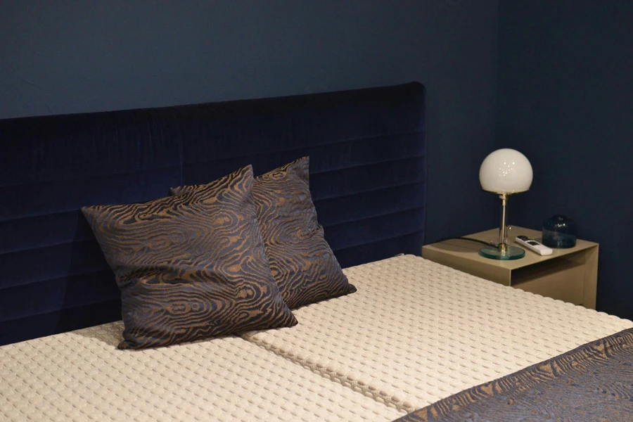 Bed with mattresses and decorative cushions in hotel room