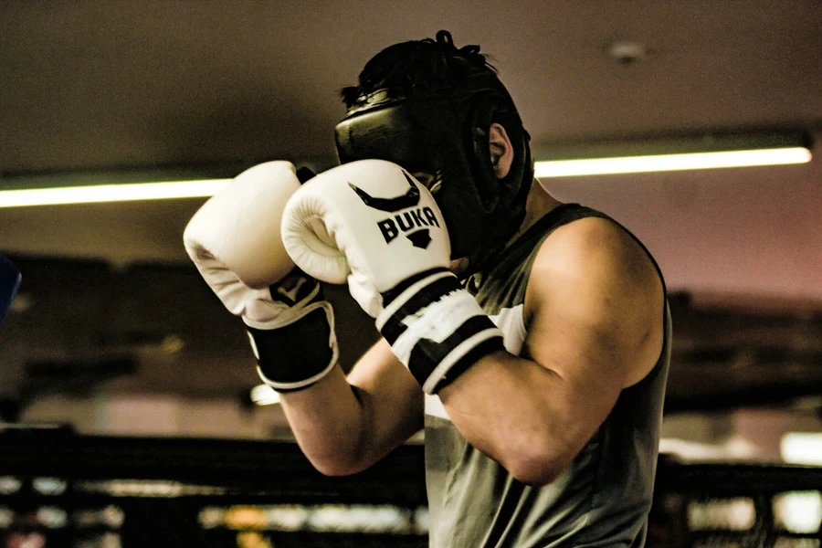 Boxing gloves protecting a man’s face