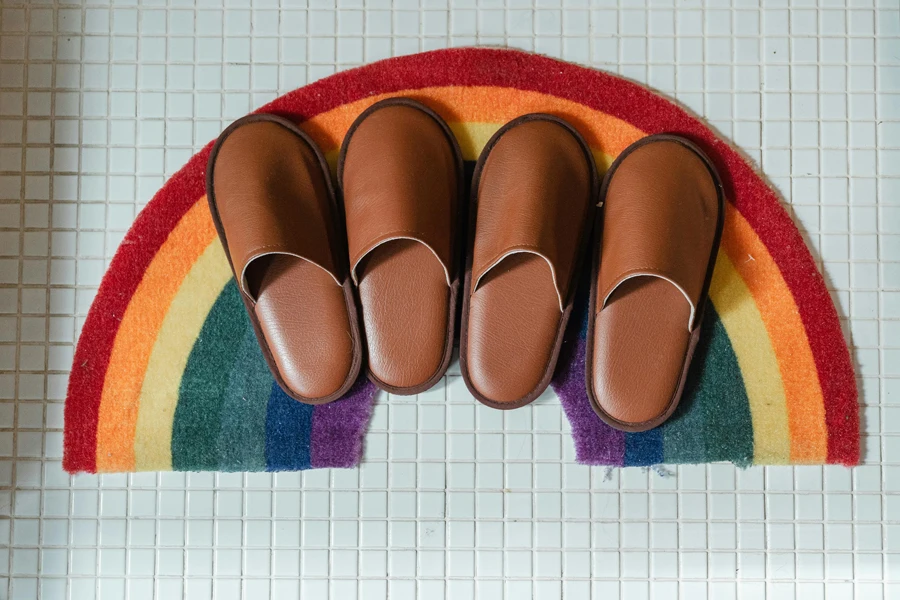 Brown leather slippers on rainbow bathroom mat