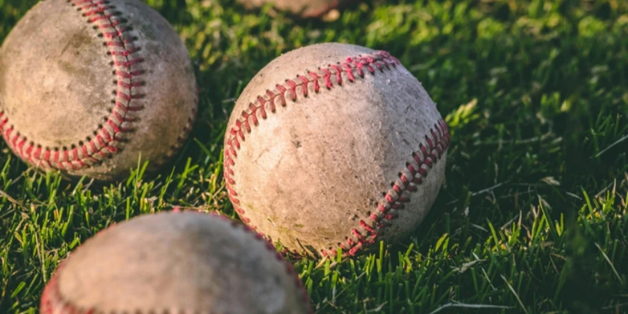 Close Up Photography of Four Baseballs on Green Lawn Grasses