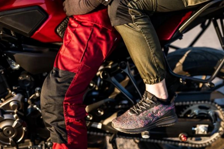 Couple with motorcycle pants sit on motorcycle