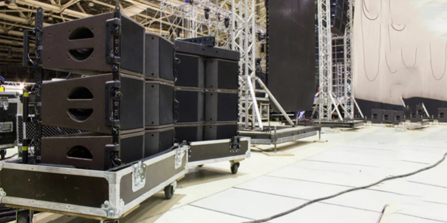 Flight cases with line array speakers. Stage, trusses, led screen and sound speakers background. Installation of professional concert equipment