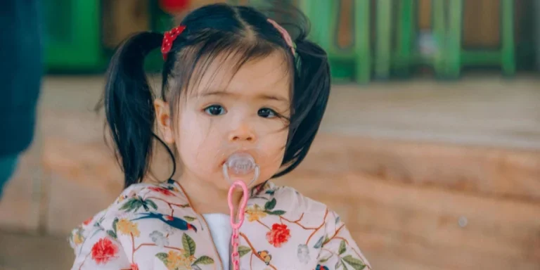 Девочка в топе с белым, красным и желтым цветочным принтом